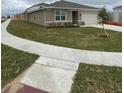 Side view of a charming single-story home with well-maintained lawn and a two car garage at 1575 Aspen Ave, Davenport, FL 33837