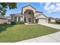Inviting two-story home with a well-kept lawn and classic architectural details at 231 Chestnut Creek Dr, Apopka, FL 32703