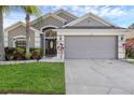 Charming home featuring a well-manicured lawn, tropical landscaping and a two-car garage at 2520 Oakington St, Winter Garden, FL 34787