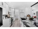 Modern kitchen with white cabinetry, black marble countertops, and sleek, stainless steel appliances at 2520 Oakington St, Winter Garden, FL 34787