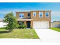 Inviting two-story home featuring a two-car garage, covered entry, and fresh landscaping at 2752 Grand Central Ave, Tavares, FL 32778