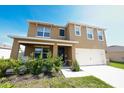 Charming home with covered porch, a two-car garage, and front yard landscaping at 2752 Grand Central Ave, Tavares, FL 32778