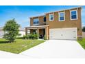 Welcoming two-story home with a two-car garage, covered porch, and well-maintained front yard at 2752 Grand Central Ave, Tavares, FL 32778