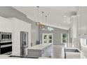 Open-concept kitchen with stainless appliances, a central island, and views of a serene pond at 2776 Joseph Cir, Oviedo, FL 32765