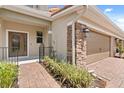Charming townhouse entrance features a stone pillar, landscaped walkway, and inviting front door at 299 Terracina Dr, Sanford, FL 32771