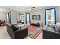Bright living room boasts tile floors, ceiling fan and sliding glass door to screened patio at 299 Terracina Dr, Sanford, FL 32771
