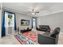 Bright living room with tile floor, two couches, ceiling fan and large windows with curtains at 299 Terracina Dr, Sanford, FL 32771
