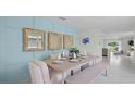 Dining room with a blue accent wall, decorative mirrors, table set for four, and open access to the kitchen at 3665 Marlberry Way, Sanford, FL 32773