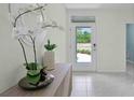 Bright foyer featuring neutral walls, modern decor and a view to the outdoors through a glass front door at 3665 Marlberry Way, Sanford, FL 32773