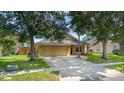 Lovely home with mature trees shading the front yard, and a driveway leading to a two-car garage at 400 Bridge Creek Blvd, Ocoee, FL 34761