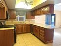 Well-equipped kitchen featuring wood cabinets, tiled backsplash, and an island with counter seating at 4105 Quando Dr, Belle Isle, FL 32812