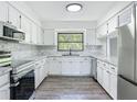 Bright kitchen with white cabinets, modern appliances, and marble countertops at 43 Lake Court Loop, Ocala, FL 34472
