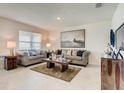 Bright living room featuring stylish sofas, a neutral rug, modern artwork and a large window at 5169 Masser Rd, St Cloud, FL 34772