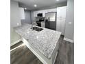 Modern kitchen with granite countertops, stainless steel appliances, and white cabinets at 534 Central Ave, Frostproof, FL 33843