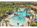 Large community pool featuring a water slide, palm trees, and seating areas at 5353 Oakbourne Ave, Davenport, FL 33837