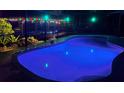 Night view of pool featuring underwater lighting and covered seating area with festive decorations at 5370 Whispering Pine Cir, St Cloud, FL 34771