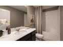 Cozy bathroom features a vanity with a large mirror and a shower-tub combination with a shower curtain at 7546 Headwaters Ct, Groveland, FL 34736