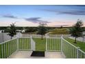 Spacious backyard view with white fence and tranquil scenery of a lake and surrounding green space at 818 Kapi Dr, Groveland, FL 34736