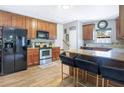 Kitchen features wood cabinets, stainless steel appliances, granite countertops and island with bar stool seating at 1032 Perkins Rd, Orlando, FL 32809
