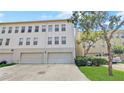 View of the back of the three story townhouse with two garage doors and a vehicle parked in the driveway at 1038 Waterside Dr, Celebration, FL 34747