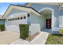 Close-up of home's entrance featuring an attached garage and red front door at 11836 Hartfordshire Way, Orlando, FL 32824