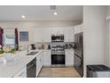 Modern kitchen with stainless steel appliances, white cabinets, and quartz countertops, offering a sleek design at 146 E 15Th St, Apopka, FL 32703