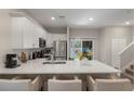 Open kitchen featuring a spacious quartz island with seating, stainless appliances, and ample natural light at 146 E 15Th St, Apopka, FL 32703