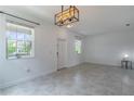 Bright living room showcasing neutral walls, modern light fixture, and tile floors for a clean aesthetic at 15030 Book Club Rd, Winter Garden, FL 34787