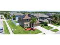 Stunning aerial view showcasing home with solar panels, lush landscaping and neighborhood pond at 1902 Hailsham Ct, Orlando, FL 32824