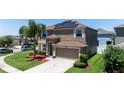 Inviting two-story home with a well-manicured lawn, solar panels, and an attached two-car garage at 1902 Hailsham Ct, Orlando, FL 32824
