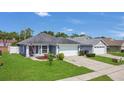 Well-kept home with lush green lawn, attached garage, and a pleasant exterior paint scheme at 204 Bay Meadow Dr, Kissimmee, FL 34746