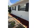 Side view of home with black shutters, manicured mulch and a water hose at 205 Brighton Way, Casselberry, FL 32707