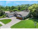 Aerial view of a home with manicured lawn, brick driveway, and mature trees at 2106 Tuscarora Trl, Maitland, FL 32751