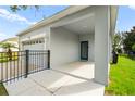 Covered entrance showcasing a blue front door, neutral exterior paint, and black metal fencing at 2125 Shackley Pl, Apopka, FL 32703