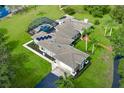 Aerial view showcasing a home with a screened-in pool, solar panels, a driveway, and manicured landscaping at 2326 Florida Ave, Oviedo, FL 32765
