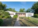 Inviting single-story home with a well-kept lawn and mature landscaping leading to the front entrance at 2361 Kimberly Dr, Deltona, FL 32738