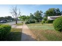 Residential street view showcases the home's front yard with established landscaping and green painted driveway at 2361 Kimberly Dr, Deltona, FL 32738