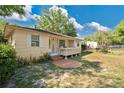 Inviting single story home featuring a quaint porch and a spacious yard with mature landscaping at 2409 Garbelia Ave, Orlando, FL 32817