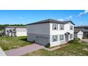 Beautiful two-story home with a side-entry garage and brick paver driveway, showcasing modern design and well-kept landscaping at 596 Sun Warbler Way, St Cloud, FL 34771
