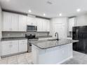 Modern kitchen featuring white cabinets, granite countertops, stainless steel appliances, and a functional center island at 596 Sun Warbler Way, St Cloud, FL 34771
