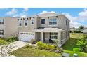 Attractive two-story home with a covered front porch, a two-car garage and lush landscaping at 616 Griffon Ave, Lake Alfred, FL 33850