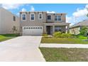 Inviting two-story home with a well-manicured lawn, two-car garage, and a covered front porch at 616 Griffon Ave, Lake Alfred, FL 33850