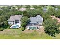 Backyard aerial view highlighting the screened pool, lush landscaping and mature trees on this large private lot at 6161 Blakeford Dr, Windermere, FL 34786
