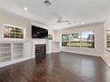 Bright living room with hardwood floors, built-in shelving, and large windows offering natural light at 6161 Blakeford Dr, Windermere, FL 34786