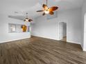 Spacious, bright living room with wood-look tile flooring and contemporary ceiling fans at 84 Camino Real Blvd, Howey In The Hills, FL 34737