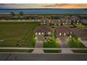 Beautiful aerial view of a neighborhood with a serene lake backdrop and colorful sunset at 850 Lazio Cir, Debary, FL 32713
