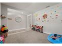 Bright and airy living room with neutral carpet and wall decorations, creating a playful atmosphere at 850 Lazio Cir, Debary, FL 32713