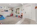 Spacious living room with neutral carpet and colorful wall decorations, filled with toys at 850 Lazio Cir, Debary, FL 32713