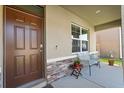 Inviting front porch with a cozy seating area and decorative brick accents at 850 Lazio Cir, Debary, FL 32713