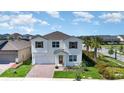 Elevated angle of a two-story home with a brick driveway, lush landscaping, and a view of the neighborhood beyond at 9027 Coral Cape St, Kissimmee, FL 34747